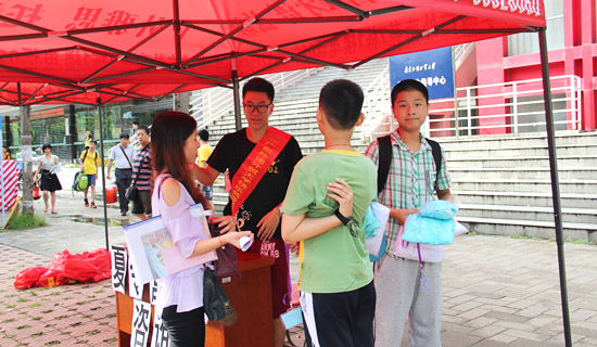 南校区学生活动中心门口,工作人员热情地为学生家长指引报到流程